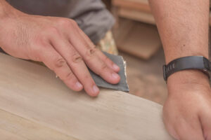 Hand mit Scheifpapier auf Holz. Bildrechte Mdv Edwards-stock.aobe.com